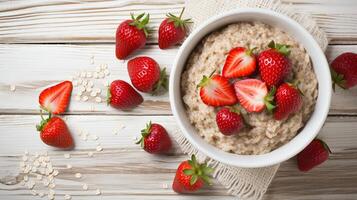 AI generated Nutritious oatmeal porridge bowl with fresh strawberry on white table, healthy diet breakfast option photo