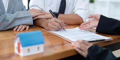 Young couple signing contract agreement with real estate agent. photo