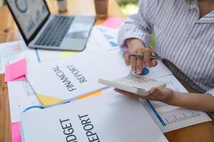 accounting concept. businesswoman working using calculator with money stack in office photo