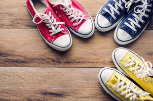 Multicolored sneakers on wooden floor photo