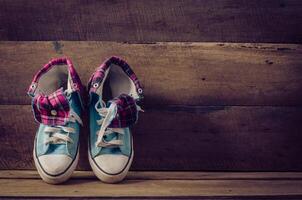 Sneakers on floor on wooden background photo