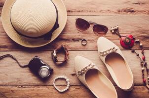 Hats, shoes and accessories to dress lay on the wooden floor for travel - Vintage tone. photo