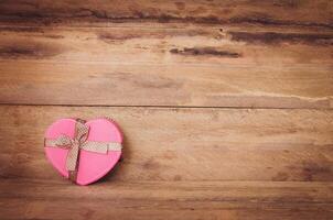 Heart shaped Valentine's Day gift box on wooden background. photo