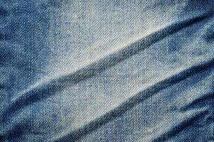 Wrinkles blue jeans texture. Jeans background. photo