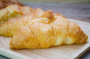 croissants en plato en de madera mesa foto