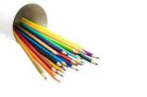 Stack of colored pencils in a glass on white background photo