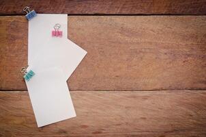 Note paper clip on a wooden floor. photo