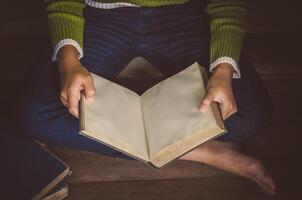 reading book on wooden floor with book - tone vintage photo