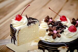 Birthday cake, vanilla Chocolate Cherry was divided pieces on a wooden table. photo