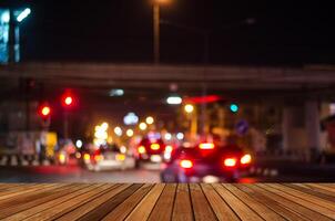 Wooden plank and blurred bokeh image of traffic jam at nightf traffic jam at night photo