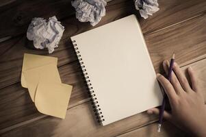 Hand-written note in pencil on a wooden table - hand focus photo