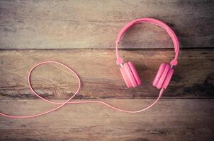 Pink headphones on the wooden floor photo