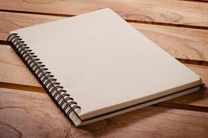 White notebooks laying on a wooden table photo