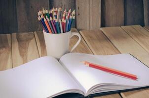 Color pencil and sketchbook on wood table photo