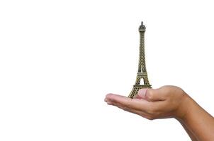 Open hand with a model the Eiffel Tower on white background. photo