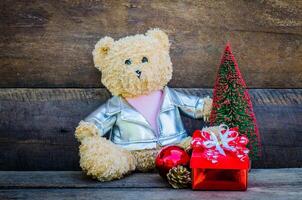 teddy bear and gift on wooden background photo