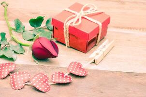 roses and gift box on wooden background photo