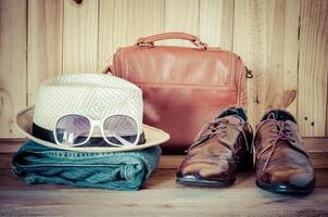 viajes, accesorios, vaqueros, sombreros, zapatos, gafas de sol, Listo para el viaje en de madera backgrond foto