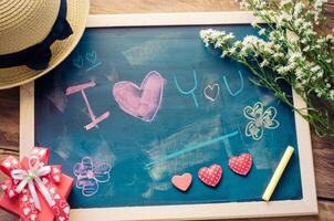 Blackboard with words written in shock that the I LOVE YOU and a floral heart was placed next to the board - the concept of Valentine's Day. photo