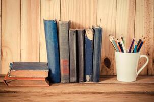 color pencil old books on a wooden table. photo