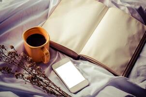 Notebooks,coffee cup,smart-phone, on the bedroom at morning photo