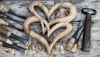 corazón madera es metido en un de madera piso y un tallado madera pegar. foto