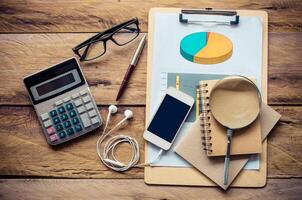 costume calculator, pen, notebook and accessory for work on wooden table. photo