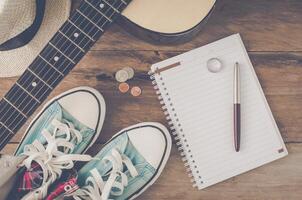 Accessories for relax at holiday, notebook and pen, guitar for trip - tone vintage photo