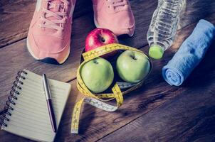 fitness concept with Exercise Equipment on wooden background. photo