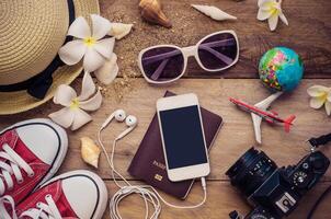 Top view travel accessories for summer on wooden background photo