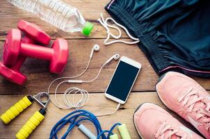 fitness concept with Exercise Equipment on wooden background. photo