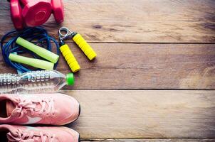 fitness concept with Exercise Equipment on wooden background. photo