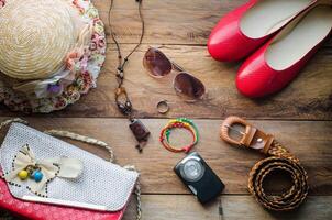 accessories for teenage girl on her vacation, hat, stylish for summer sunglasses, leather bag, shoes and costume on wooden floor photo