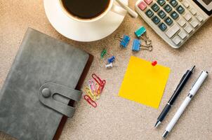 Note placed on the table and a cup of coffee office supplies on the table. photo