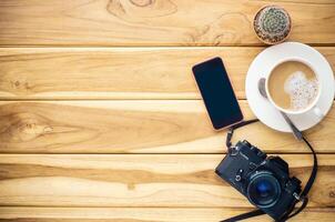 café taza, cámara, inteligente teléfono en madera foto