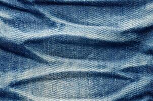 Wrinkles blue jeans texture. Jeans background. photo