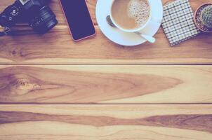 coffee cup, camera, smart phone on wood photo