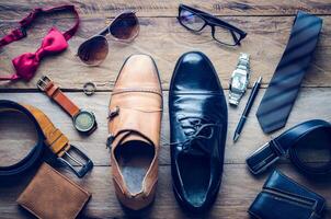 Leather shoes and accessories for work lay on the wooden floor photo