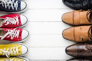 Sports shoes, work shoes, put on a white wooden floor - a living concept. photo