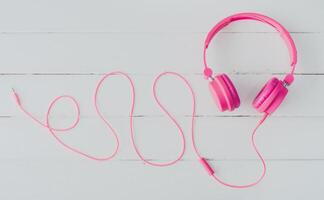 rosado auriculares en el de madera piso foto
