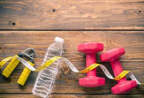 fitness concept with Exercise Equipment on wooden background photo