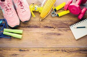 fitness concept with Exercise Equipment on wooden background. photo