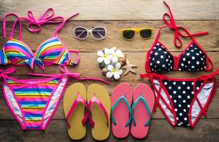 biquinis, Gafas de sol, zapatos, dos conjuntos metido en un de madera piso foto
