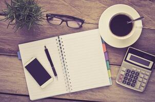 pen, notebook and accessory for work on wooden table photo