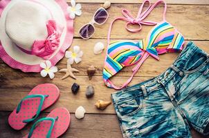 Beauty colorful bikini and accessories on wooden floor photo