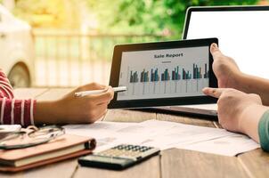 Business team analysis with financial graph in tablet at office, workplace, meeting photo