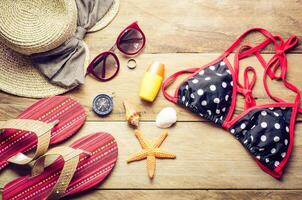 Beauty colorful bikini and accessories on wooden floor for trip on summer photo