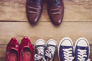 Father's shoes Placed in front of mother's shoes with baby on wooden floor - Concept of family leader. photo