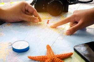 Tourists are planning a trip on a map and mark a place of interest. photo