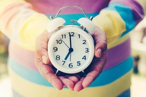 Hands holding a clock give the concept a time. photo